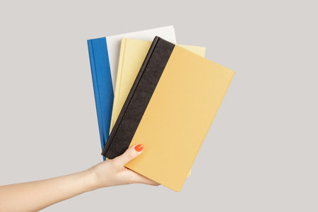 Closeup of woman hand showing lots textbooks or organizers, education, reading literature. Indoor...