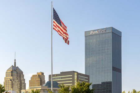 Oklahoma City, USA - October 25th, 2023: View of the modern BancFirst bank tower and flag of United States of America.のeditorial素材