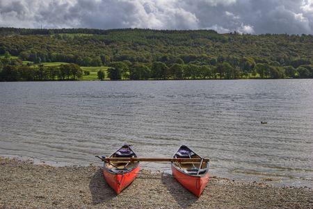 Canoes on the shore of Coniston Water in the English lake Districtの写真素材
