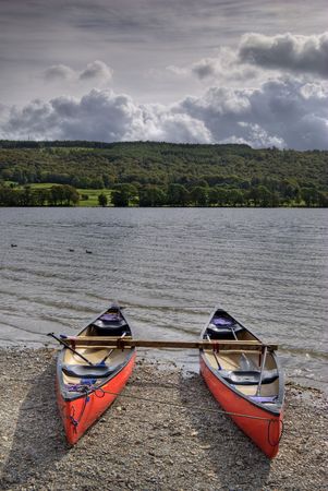 Canoes on the shore of Coniston Water in the English lake Districtの写真素材