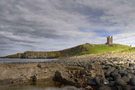 Dunstanburgh Castle, cliffs, and rocky coast in Northumberland, Englandの写真素材