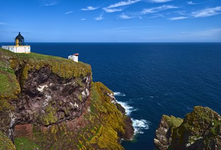 Pettico Wick is a beautiful inlet on Scotlands East Coast. The white lighthouse stands on the clifftopの写真素材