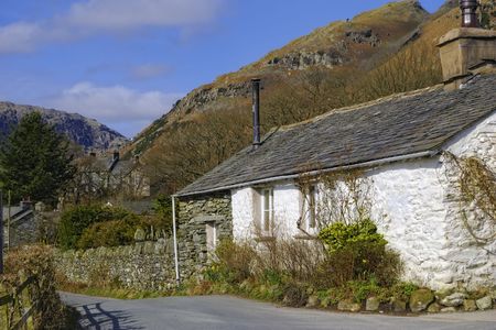 White cottage in countryside with mountainous background, Little Langdale village, Lake District, Cumbria, Englandの写真素材