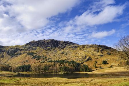 Scenic view of mountainous landscape of Lake District with Blea Tarn lake in foreground, Cumbria, Englandの写真素材