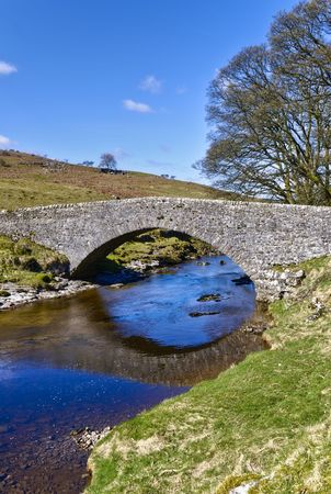 Scenic view of stone packhorse bridge over river Wharfe, Wharfedale Valley, Yorkshire, England.の写真素材