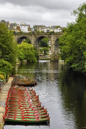 Scenic view of Knaresborough town viaduct over river Nidd with rowing boats moored in foreground, North Yorkshire, Englandの写真素材