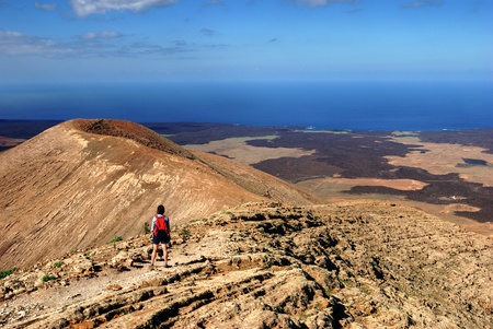 A female hiker on a mountain trail on Lanzarote, in the Spanish Canary Islands.の写真素材