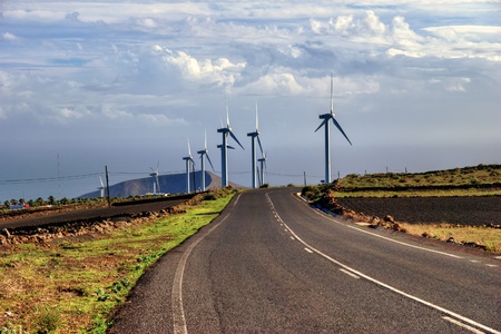 A road passes through a wind farm in the countryside.の写真素材