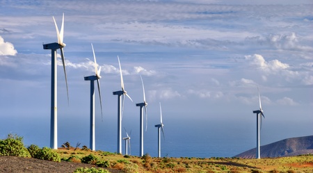 Scenic view of turbines on wind farm in countryside with sea and cloudscape background.の写真素材