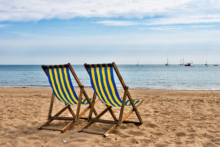 Two deckchairs on a sandy beach at Swanage, South West Englandの写真素材