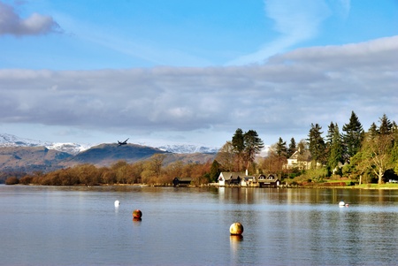 Beautiful mountain lake scene with reflections of buildings and treesの写真素材