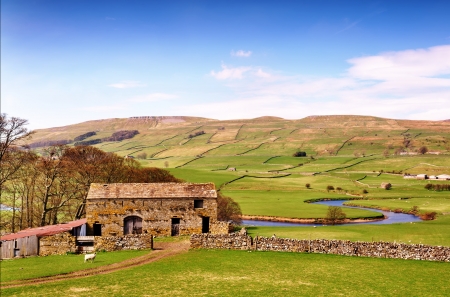 A stone built barn and trees by the River Ure, winding its way through the peaceful countryside of the Yorkshire Dales, Englandの写真素材