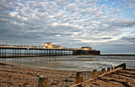 View of the Grade 2 listed Victorian pier at Worthing, West Sussex, built in 1862, with shingle beach and  wooden groynesの写真素材