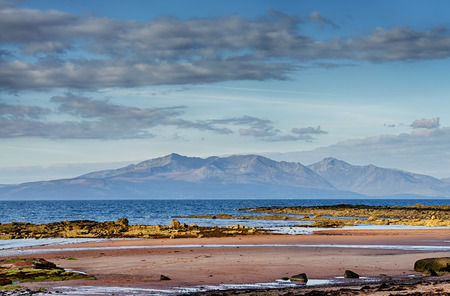 Scenic view of the Isle of Arran pictured over the Firth of Clyde from the coast of West Kilbride in Scotland.の写真素材