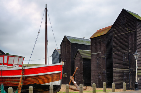 Closeup of a painted fishing boats with wooden huts in the background.の写真素材