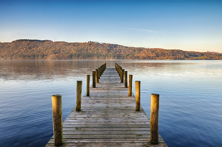 Perspective view of a wooden jetty on Windermere in the English Lake District, on a sunny, calm morning.の写真素材