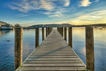 A jetty on a calm Windermere at sunset.の写真素材