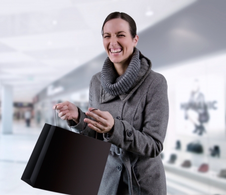 Young woman in winter coat purchases in bagsの写真素材