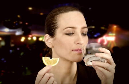 Young beautiful woman in the club drinking alcohol with limeの写真素材