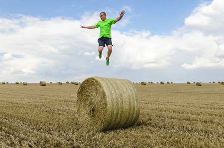Young man on a bale of strawの写真素材