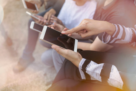Mockup image of  white mobile phone with blank black screen.Teamwork group Looking for information needed for working on the internet through mobile phones.の写真素材