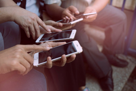 Mockup image of  white mobile phone with blank black screen.Teamwork group Looking for information needed for working on the internet through mobile phones.の写真素材