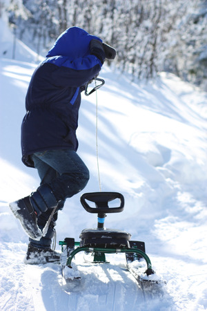 A boy neare the  sledge in winter の写真素材