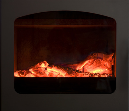 Smoldering embers behind glass fireplaceの写真素材
