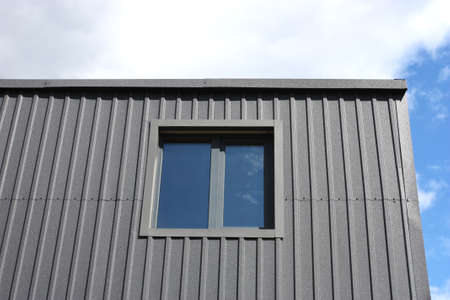 Facade of a house made of black metal with a window