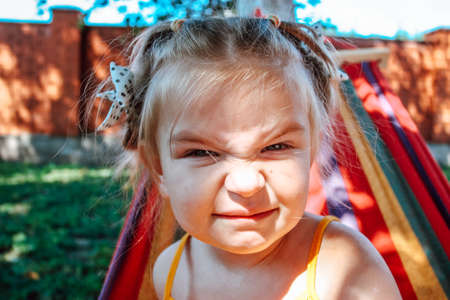 Little girl in a bad mood makes faces