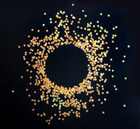 Golden glitters stars round frame on black backgroundの写真素材