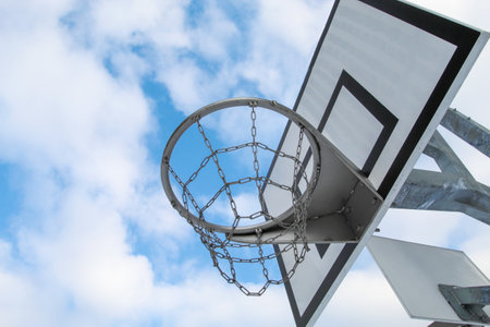 Street basketball hoop, net and board against the background of the blue sky and cloudsの写真素材