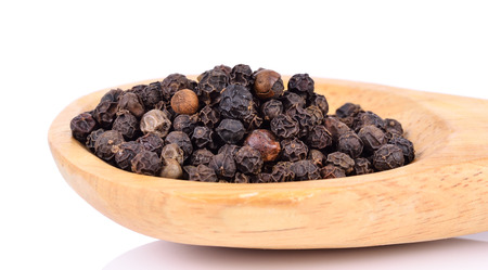 Black pepper on wooden spoon on  white background.