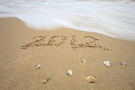 write 2012 on sand beach and sea waveの写真素材