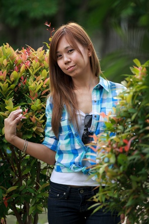 asian women standing in the park with green tree の写真素材
