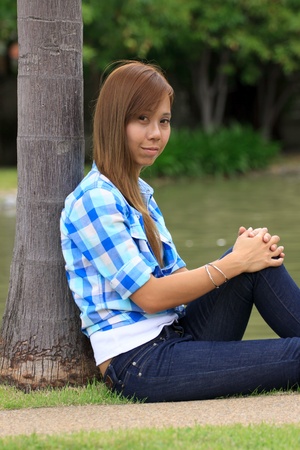 asian women sitting on the ground in the parkの写真素材