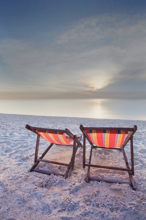 couples of wood teak chairs beacn and sun set sceneの写真素材