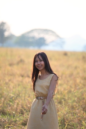 face of women standing in the grass field with evening light の写真素材