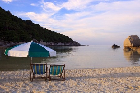 couples chairs beach and umbrella at sea sideの写真素材