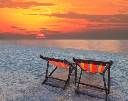 couples chairs beach on sand beach with colorful skyの写真素材
