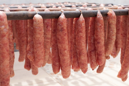 thai local pork sausage style drying on the bamboo line prepare for saleの写真素材