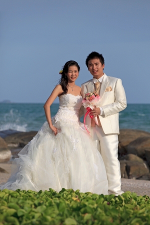 man and woman  in wedding suit at sea beachの写真素材