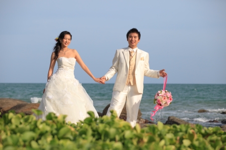 man and woman  in wedding suit at sea beachの写真素材