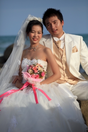 man and woman  in wedding suit at sea beachの写真素材