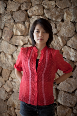 asian woman standing in font of rock wallの写真素材