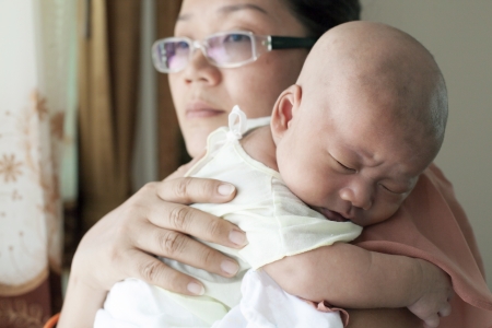 mother hug baby in her breastの写真素材