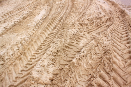pattern of tractor wheel printed on sand beach use as nature backgroundの写真素材