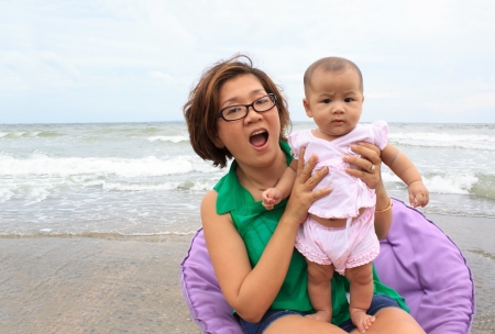 face of mother and baby at sea beachの写真素材