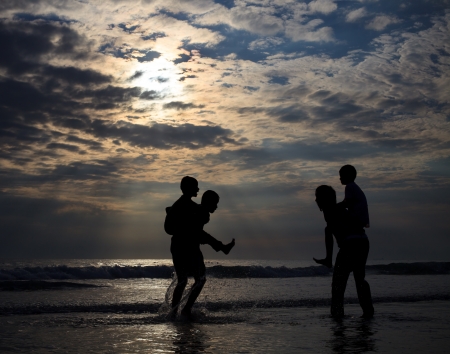 children playing on sea beach in the evening ligntの写真素材