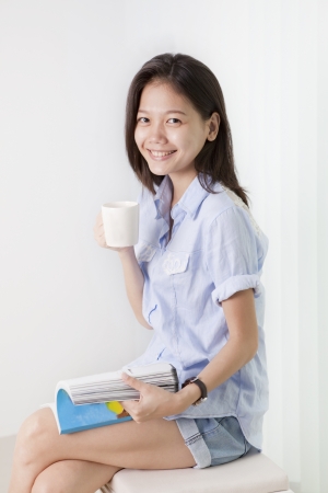 face of asian woman holding a cup of hot coffeeの写真素材